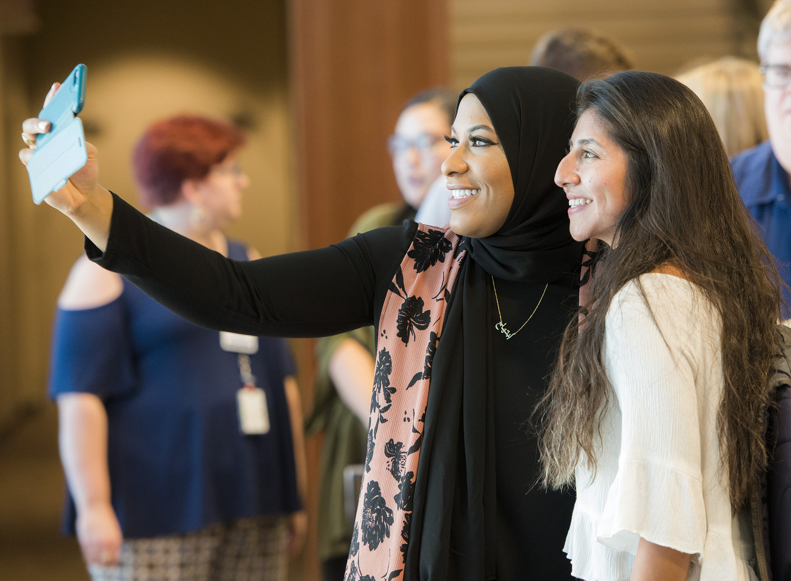 Ibtihaj Muhammad takes a selfie with a fan